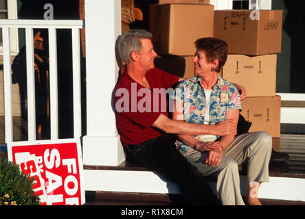Älteres Ehepaar mit beweglichen Kästen auf der Veranda eines Hauses, USA Stockfoto