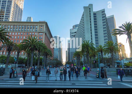 Fußgänger warten an der Ampel mit San Francisco Downtown im Hintergrund, Kalifornien, USA, bei Sonnenuntergang. Stockfoto