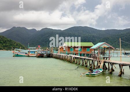 Tropische Landschaft mit Türkis tropischen Meer, Angeln, Boot, Haus auf dem Wasser, Holz- pier und tropischen Koh Chang Insel am Horizont in Thailand Stockfoto