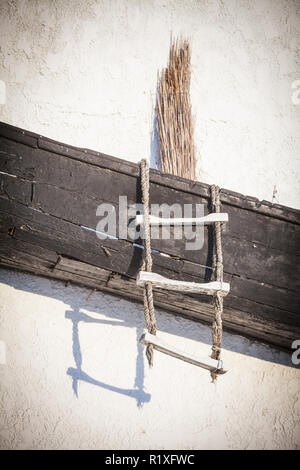 Eine alte verlassene Holz- Boot auf einer Wand angezeigt. Stockfoto