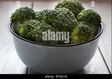 Broccoli roh. Stapel von frischem Brokkoli in der Schüssel auf dem Tisch. Stockfoto