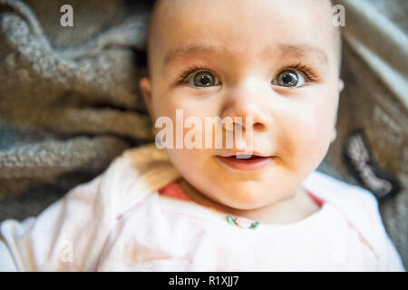 Ein Porträt von einem 6 Monat cute baby girl liegend Stockfoto