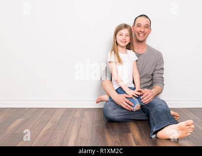 Ein Vater mit seiner Tochter auf der Erde sitzen Stockfoto