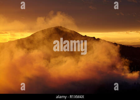 Sattel Hill und smokey Sonnenuntergang von Feuer an Burnside, Dunedin, Südinsel, Neuseeland Stockfoto