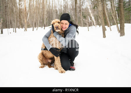 Eine Frau mit goldendoodle Wintersaison Stockfoto