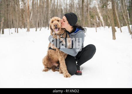 Eine Frau mit goldendoodle Wintersaison Stockfoto