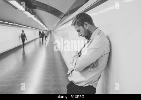 Verzweifelte traurige junge Unternehmer leiden emotionalen Schmerz, Trauer und tiefe Depression allein sitzen im Tunnel", der U-Bahn im Stress leben Arbeit Probleme f Stockfoto