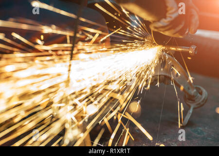 Proffecional Arbeiter Reparatur Auto teil mit Winkelschleifer. Viele Funken für den Hintergrund. Stockfoto