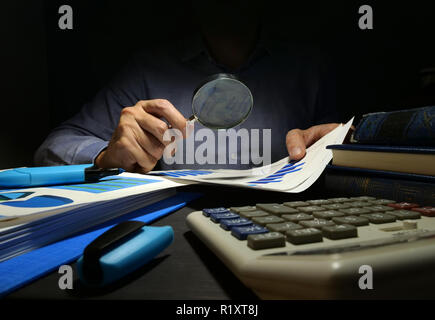 Prüfer prüft Finanzbericht mit Lupe. Internes Audit und Business Analyse. Stockfoto