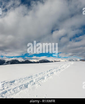 Schlitten trace und Fußabdrücke auf Winter Berg Hügel und Schnee bedeckten malerischen Alp Chornohora Ridge (Ukraine, Karpaten, Ruhe Stockfoto