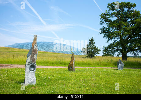 Dome Glas dach der Großen Gewächshaus des Nationalen Botanischen Garten von Wales und Skulpturen aus Stein. Stockfoto
