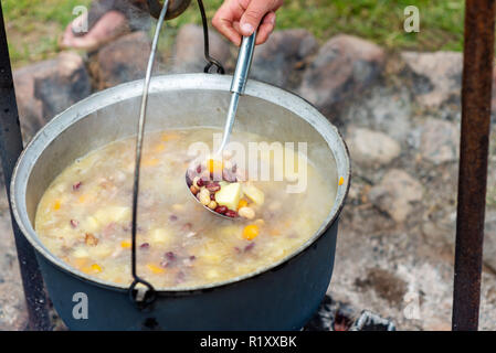 Kochen in einem Topf am Lagerfeuer. Sommer Camping Konzept. Stockfoto