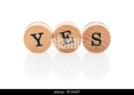 Wort Ja aus kreisrunden Holz Fliesen mit Buchstaben Kinder Spielzeug. Konzept der Genehmigung in Kinderspielzeug Buchstaben geschrieben. Stockfoto