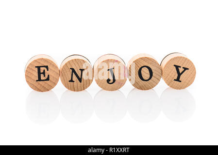 Wort genießen Sie vom Circular Holz Fliesen mit Buchstaben Kinder Spielzeug. Konzept des Genießens in Kinderspielzeug Buchstaben geschrieben. Stockfoto