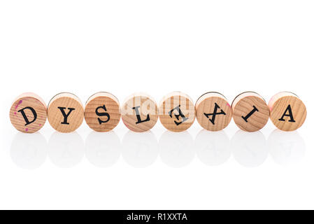Wort Legasthenie aus kreisrunden Holz Fliesen mit Buchstaben Kinder Spielzeug. Konzept des Lernens Schwierigkeiten Unordnung in Kinderspielzeug Buchstaben geschrieben. Stockfoto