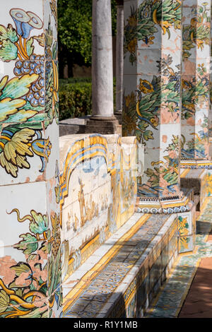 Bunte Fliesen- Säulen und Sitzbank im Garten des Kreuzgangs im Santa Chiara Kloster in der Via Santa Chiara, Neapel Italien. Stockfoto