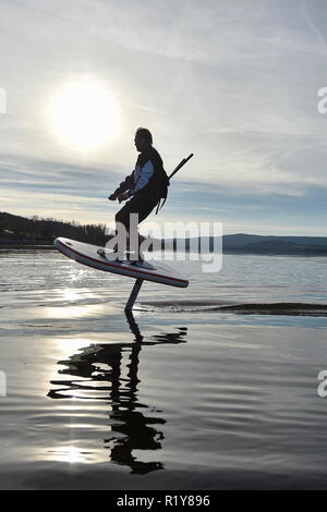 Tschechische surfer Petr Benes reitet seine elektrischen foilboard (Tragflügelboot, Efoil, Folien, paddleboard) am Stausee Lipno, Tschechien, 15. November 2018. (CTK Photo/Vaclav Pancer) Stockfoto