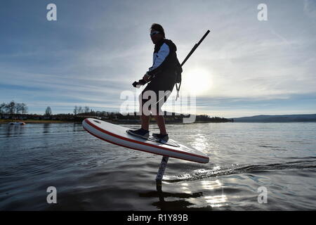 Tschechische surfer Petr Benes reitet seine elektrischen foilboard (Tragflügelboot, Efoil, Folien, paddleboard) am Stausee Lipno, Tschechien, 15. November 2018. (CTK Photo/Vaclav Pancer) Stockfoto