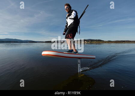 Tschechische surfer Petr Benes reitet seine elektrischen foilboard (Tragflügelboot, Efoil, Folien, paddleboard) am Stausee Lipno, Tschechien, 15. November 2018. (CTK Photo/Vaclav Pancer) Stockfoto