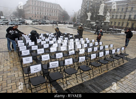 Kiew, Ukraine. 15 Nov, 2018. Aktivisten befestigen Sie Blätter mit den Namen der ukrainischen politischen Gefangenen in Russland zu Stühlen, bei der symbolischen Leistung als "Freie Stühle auf der St. Michael's Square in Kiew. Die Kundgebung richtet Regisseur Oleg Sentsov und anderen ukrainischen politischen Gefangenen in Russland, der Krim und der Konfliktzone der Osten der Ukraine zu unterstützen. Ein leerer Stuhl symbolisiert ein Autor, der sich nicht auf ein bestimmtes Ereignis in der Haft, Haft, verschwinden, lebensbedrohliche oder Mord vorhanden sein können. Credit: Pavlo Gontschar/SOPA Images/ZUMA Draht/Alamy leben Nachrichten Stockfoto