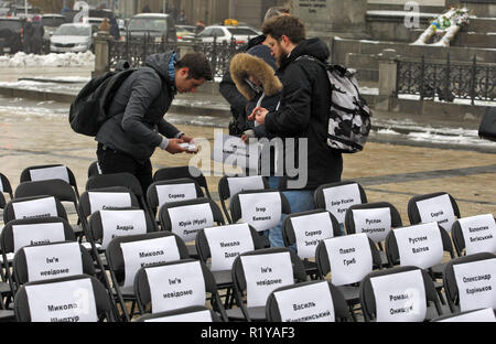 Kiew, Ukraine. 15 Nov, 2018. Aktivisten befestigen Sie Blätter mit den Namen der ukrainischen politischen Gefangenen in Russland zu Stühlen, bei der symbolischen Leistung als "Freie Stühle auf der St. Michael's Square in Kiew. Die Kundgebung richtet Regisseur Oleg Sentsov und anderen ukrainischen politischen Gefangenen in Russland, der Krim und der Konfliktzone der Osten der Ukraine zu unterstützen. Ein leerer Stuhl symbolisiert ein Autor, der sich nicht auf ein bestimmtes Ereignis in der Haft, Haft, verschwinden, lebensbedrohliche oder Mord vorhanden sein können. Credit: Pavlo Gontschar/SOPA Images/ZUMA Draht/Alamy leben Nachrichten Stockfoto