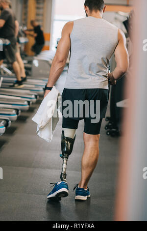 Ansicht der Rückseite des Sportlers mit künstlichen Bein zu Fuß durch Fitnessraum Stockfoto