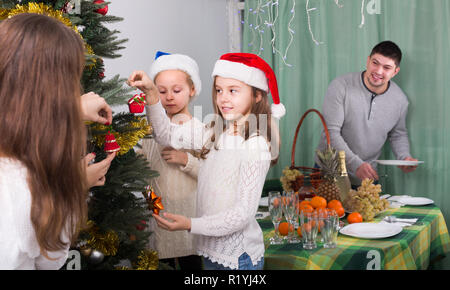 Glückliches Paar mit Kinder schmücken Weihnachtsbaum zu Hause Stockfoto