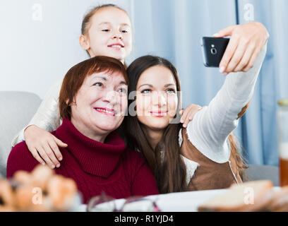 Lächelnde Frau, die selfie mit Mutter und Tochter zu Hause Stockfoto