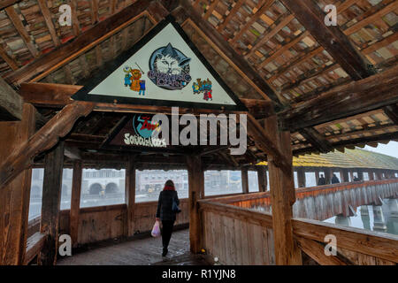 Die Kapellbrücke ist ein überdachter Holzsteg. Die Teilnehmer an den Karneval carnivalat Luzern, Schweiz ausgeliehen Stockfoto