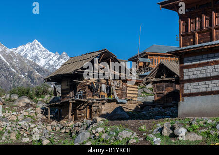 Holzhäuser des Chitkul, das letzte Dorf von Sangla Valley, bei 3.400 m entfernt, umgeben von schneebedeckten Bergen Stockfoto