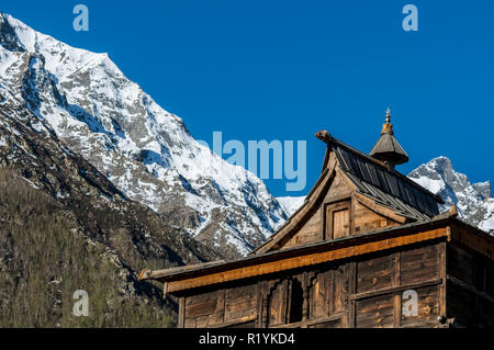 Holzhäuser des Chitkul, das letzte Dorf von Sangla Valley, bei 3.400 m entfernt, umgeben von schneebedeckten Bergen Stockfoto