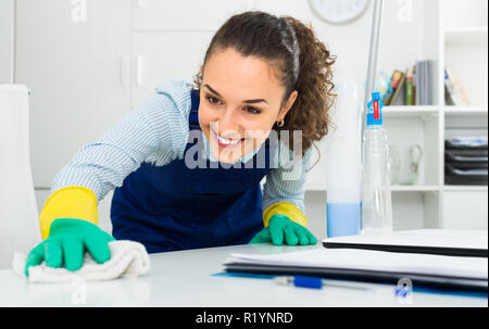 Fröhliche weiblichen professionellen Reiniger in Uniform abstauben in modernen Büro Stockfoto