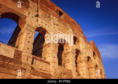 Einen malerischen Sonnenuntergang über dem Kolosseum. Detail der marmorbögen Ruinen über einen blauen Himmel, Rom, Italien Stockfoto