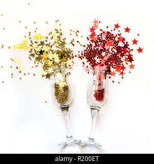 Goldene und rote Konfetti goß Gläser Champagner. Ansicht von oben. Weihnachtsfeier. Magische Nacht. Stockfoto