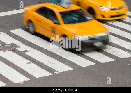 Gelbes Taxi in Bewegung auf der Fußgängerzone Streifen in Times Square, New York City, USA. Stockfoto