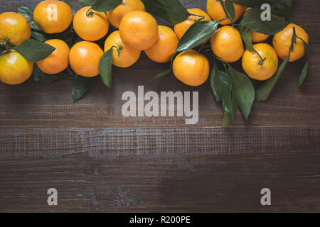 Frische reife Mandarinen mit Blättern auf Holzbrett. Weihnachten Komposition mit kopieren. Stockfoto