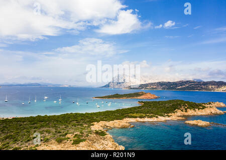 Einen spektakulären Blick auf die Insel Tavolara durch einen klaren und türkisfarbenen Meer umspült, Capo Coda Cavallo im Vordergrund, Sardinien, Italien. Stockfoto