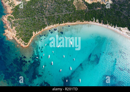 Spektakuläre Luftaufnahme von einigen Yachten und kleine Boote schwimmend auf einer klaren und türkisfarbenen Meer, Sardinien, Italien. Stockfoto