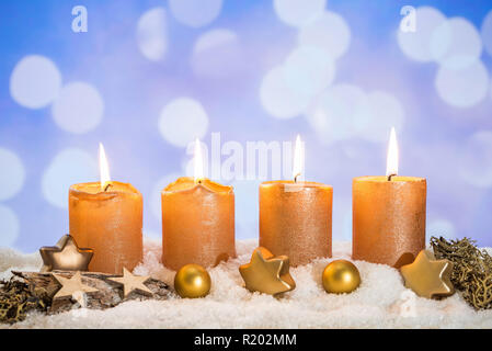 Vier goldene advent Kerzen mit vier Kerzen und Weihnachten Dekoration im Schnee liegend als Vorlage Stockfoto