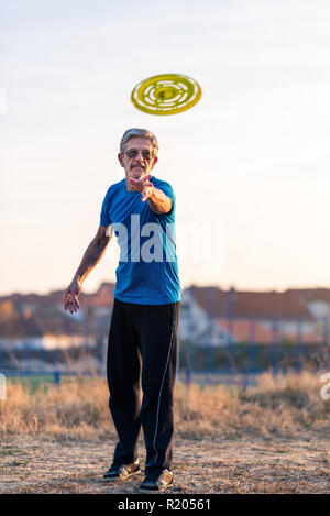 Älterer Mann spielt Frisbee im Park im Freien Stockfoto
