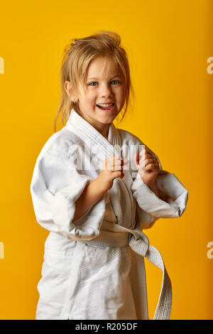 Adorable Mädchen im Kimono auf gelbem Hintergrund Stockfoto