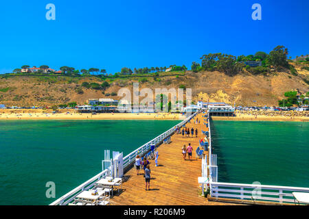 Malibu, Kalifornien, Vereinigte Staaten - 7. August 2018: Luftaufnahme von Malibu Pier, Santa Monica Mountains und Surfrider Beach. Malibu Pier ist ein historisches Wahrzeichen. Sommer Saison und blauer Himmel. Kopieren Sie Platz. Stockfoto