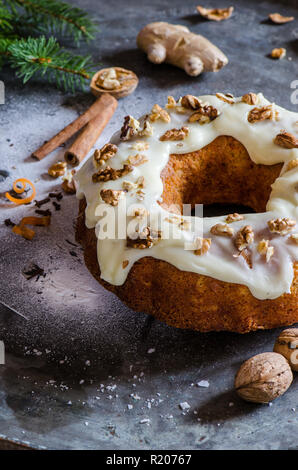 Karotten Ingwer Weihnachten Kuchen auf dem dunklen Hintergrund, dekoriert mit Zimtstangen, Walnüsse, Ingwer, Kiefer brunch und weißer Zucker Stockfoto