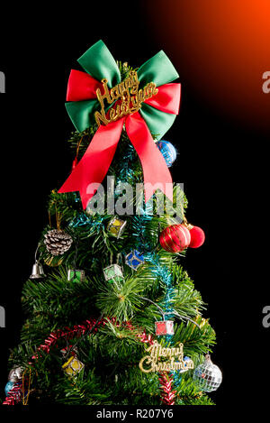 Geschmückten Weihnachtsbaum auf schwarzem Hintergrund studio Shot für Familie isoliert, wodurch, Jahreszeit, Weihnachten, Urlaub, Silvester, Reisen, Christian und Gath Stockfoto