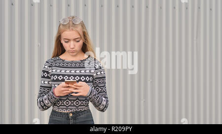 Blonde Teenager Mädchen wählt die Nummer und auf das Telefon und spricht. Stockfoto