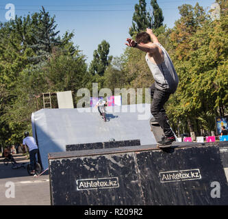 Kasachstan Almaty - 28. AUGUST 2016: Urban extreme Wettbewerb, wo die Stadt Athleten in den Disziplinen konkurrieren: Skateboards, Rollschuhe, BMX. Skateboarder einen Trick im Skate Park Stockfoto