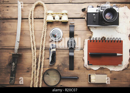 Fernglas, Lupe, Kompass und Karte auf hölzernen Tisch Stockfoto