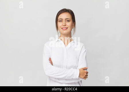 Fantastisch und freundlich lächelnd brunette in Weiß shirt Studio shot, isoliert auf weißem Stockfoto