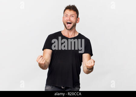 Glückliche junge Mann lächelnd portrait Sieg Geste gegen den weißen Hintergrund Stockfoto