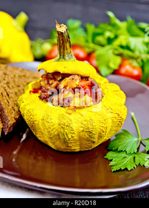 Squash gelb gefüllt mit Fleisch, Tomaten und Paprika, Brot in einen braunen, Tomaten, Petersilie auf einem dunklen Holz- Board Stockfoto